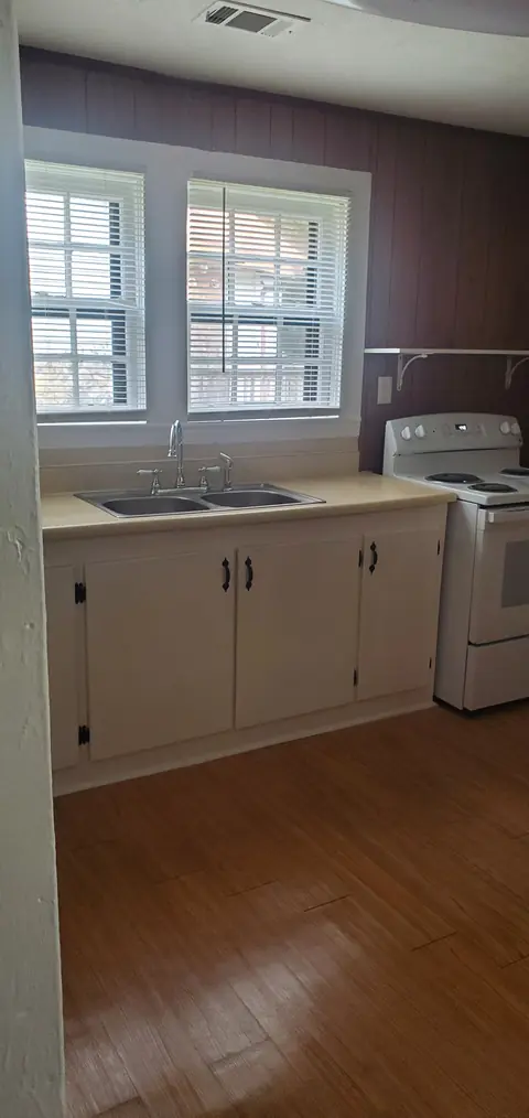 Kitchen with sink, range and white cabinets