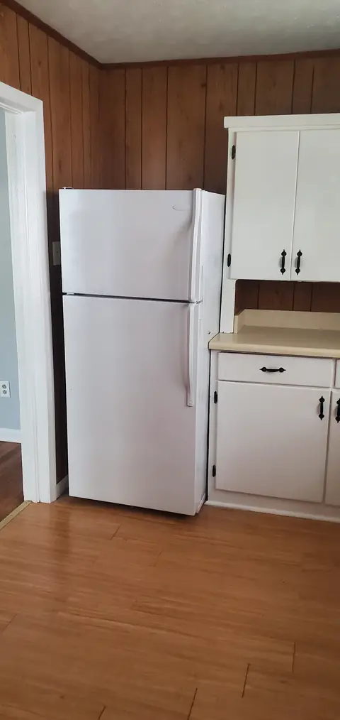 Kitchen with refrigerator and white cabinets
